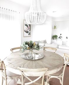 a dining room table with chairs and a chandelier hanging from it's ceiling