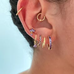 a close up of a person's ear with three different colored stones on it