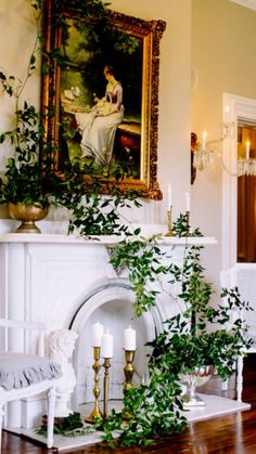 a living room filled with furniture and a fire place covered in greenery next to a painting