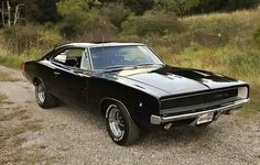 a black muscle car parked on the side of a road