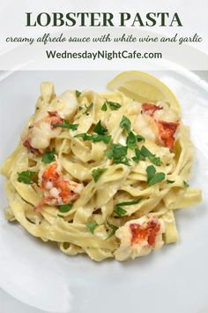 lobster pasta on a white plate with lemon wedges and parsley garnish