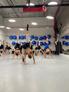 a group of people standing on top of each other in front of some blue balls