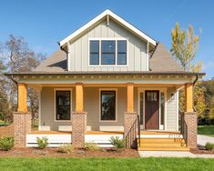 a small house with two front porches and steps leading to the front door, on a sunny day