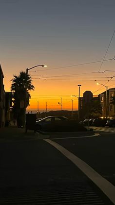 the sun is setting over a city street