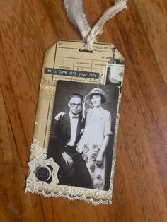 an old fashioned photo is attached to a piece of paper on a wooden table top