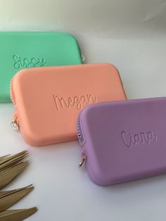 three personalized zippered pouches sitting on top of each other