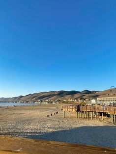 an empty beach with some buildings in the background