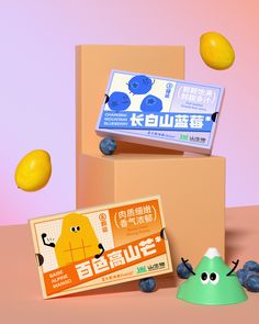 an orange and some blueberries are in front of two boxes with fruit on them