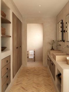 an empty bathroom with two sinks, mirrors and wooden flooring is pictured in this image