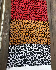 four different colors of animal print fabric on a piece of wooden flooring next to a ruler