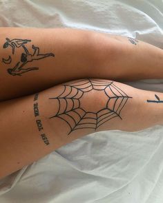 two legs with spider web tattoos on them