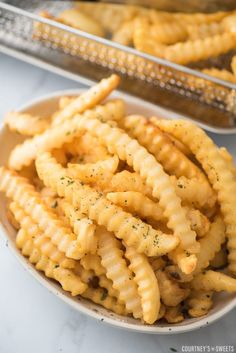 a plate full of cheesy pasta on top of a white tablecloth next to a silver grater