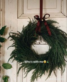 a wreath hanging on the front door of a house