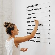 a woman writing on a white board with numbers