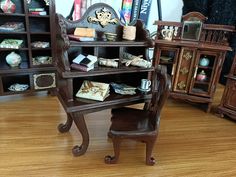 there is a miniature wooden bookcase with many items on it and in front of the bookshelf