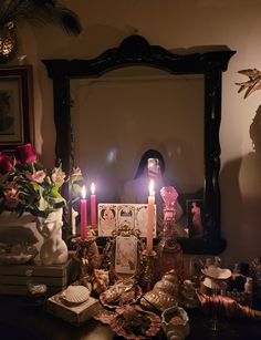 a table topped with candles next to a mirror