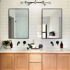 a bathroom with two sinks and mirrors on the wall