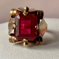 Breathtaking Vintage Retro Ring ! Huge Synthetic Cherry Red Ruby Stone ,Simply Superb !!! Done In Solid 14k Yellow Gold (Partially Visible European Stamp Of 585 And Also Tested) , Weights 6.60 Grams , Size 9 On Ring Mandrel (Probably Sizable By A Skilled Jeweler ) .The Stone Is Approx. 12x10mm In Size, Condition Is Excellent , No Eye Visible Scratches Or Damage To The Stone Of Any Kind, Gold Shows Normal Signs Of Wear. Simply Beautiful, One Of A Kind Retro Statement Ring Of European Origin Red 14k Gold Ring Gift, Heirloom Red Ruby Ring For Formal Occasions, Red Heirloom Rings For Formal Occasions, Art Deco Ruby Jewelry For Formal Occasions, Heirloom Red Rings For Formal Occasions, Heirloom Red Ring For Formal Occasions, Formal Red Rings, Formal Ruby Jewelry With Faceted Details, Red Emerald Cut Ring For Formal Occasions