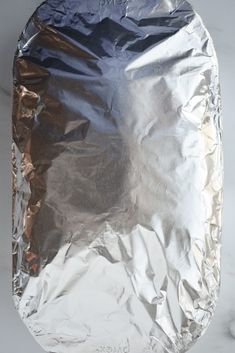 an aluminum foil covered plate sitting on top of a marble counter