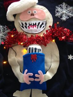 a stuffed animal holding a present under a christmas tree