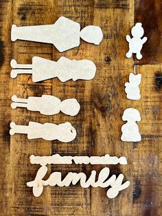 some cut out pieces of paper sitting on top of a wooden table with the word family