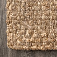 close up view of the woven fabric on top of a wooden flooring board, with wood planks in the background