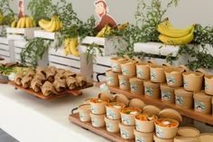 an assortment of food items displayed on wooden trays with bananas in the back ground