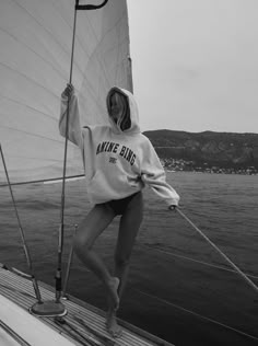 a woman standing on top of a sail boat