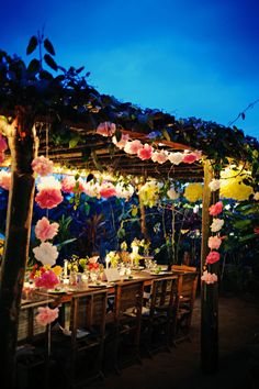 an outdoor dining area decorated with paper flowers