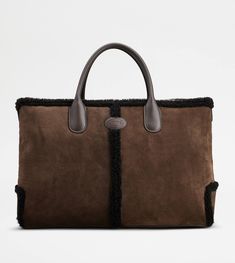 Tod's Di Bag in a refined winter version, with a shearling piping to replace the iconic central ribbing. Crafted in soft suede, with Tod's oval on the front, it features tubular handles in smooth leather and a removable shoulder strap in fabric. Complemented by an internal zipped pouch, it accompanies your everyday outfit with class. Everyday Outfit, Gift Boutique, Logo Stamp, Zip Pouch, Soft Suede, Trainers Women, Mens Trainers, Bago, Smooth Leather