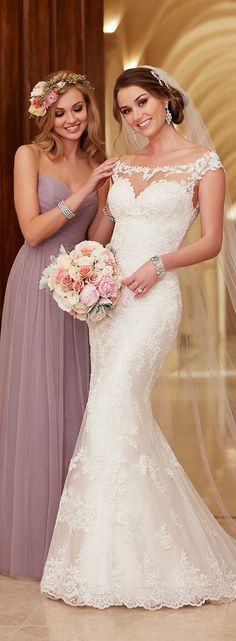 two women in dresses standing next to each other with veils over their heads and one woman