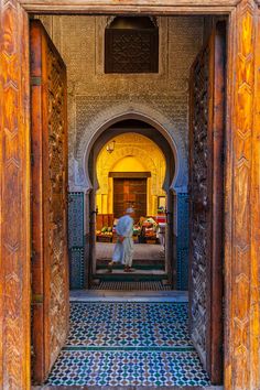 a man is walking through an ornate doorway