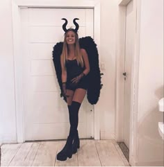 a woman dressed in devil costume posing for the camera with horns on her head and legs