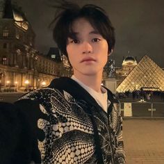 a young man is standing in front of the pyramids at night with his hands on his hips