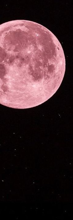 an airplane flying in front of a pink moon