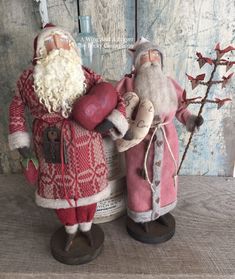 two santa claus figurines standing next to each other