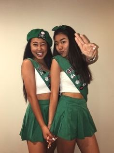 two girls dressed in green and white posing for the camera