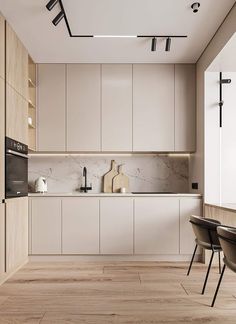 a modern kitchen with white cabinets and wood flooring is seen in this image from the dining room