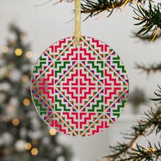 an ornament hanging from a christmas tree decorated with multicolored geometric designs