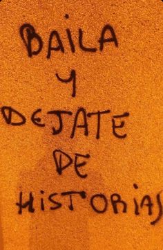 graffiti written on the side of a wall in an area with yellow walls and black writing