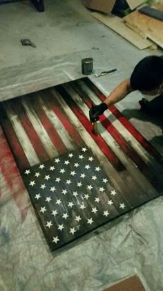 a man working on an american flag made out of wood