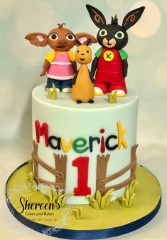 a birthday cake with three cartoon characters on top and the number one is for marverick