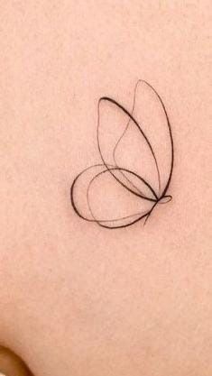 a small butterfly tattoo on the back of a woman's stomach