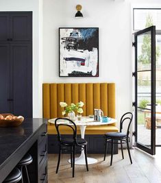 a dining room with black and yellow chairs