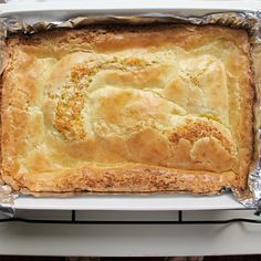 an uncooked pie sitting on top of a metal pan covered in tin foil