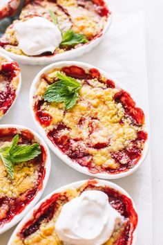 four small white bowls filled with desserts on top of a table next to each other