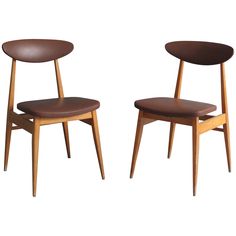 two wooden chairs with brown leather seats