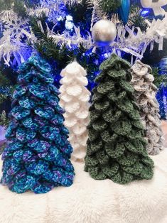 three crocheted christmas trees sitting next to each other