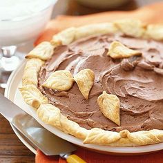 a chocolate pie on a white plate with orange napkin