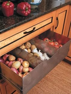 an open drawer in a kitchen filled with vegetables